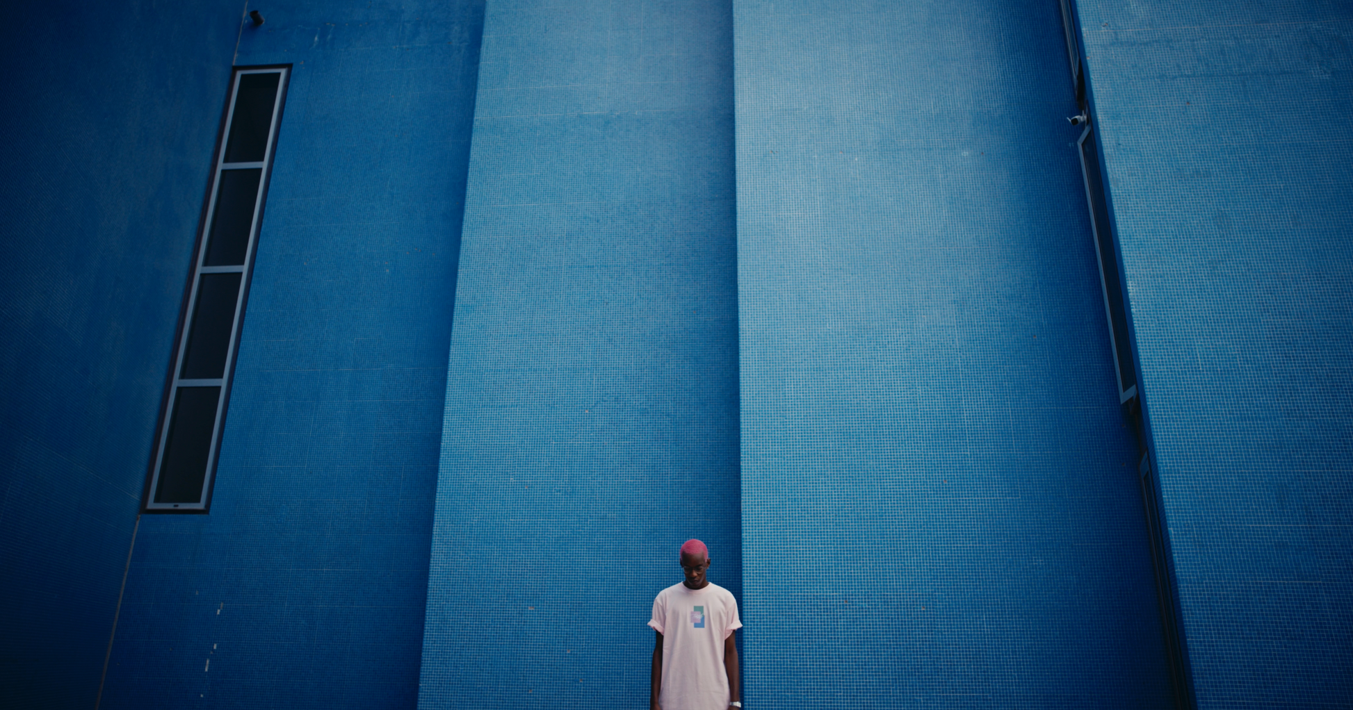 salmon DAYDREAMING box fit PASTELLE tee on model with pink hair against blue backdrop